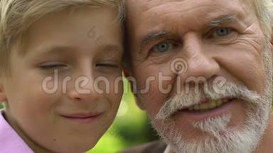 祖父和孙子的脸照着相机，微笑着，全家福